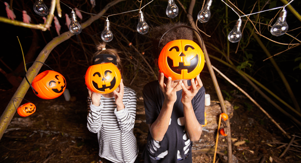 Two kids with jack o' lanterns in front of their faces during things to do in Malibu this fall. 