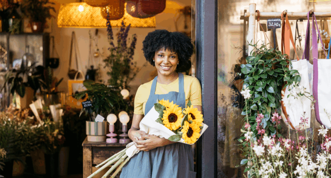 A woman holding sunflowers outside her Malibu shop