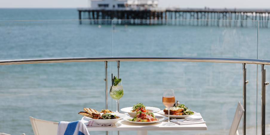 Beautifully set table on the balcony suite at Malibu Beach Inn overlooking Malibu Pier