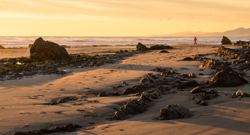 Walking along a Malibu beach at sunset.