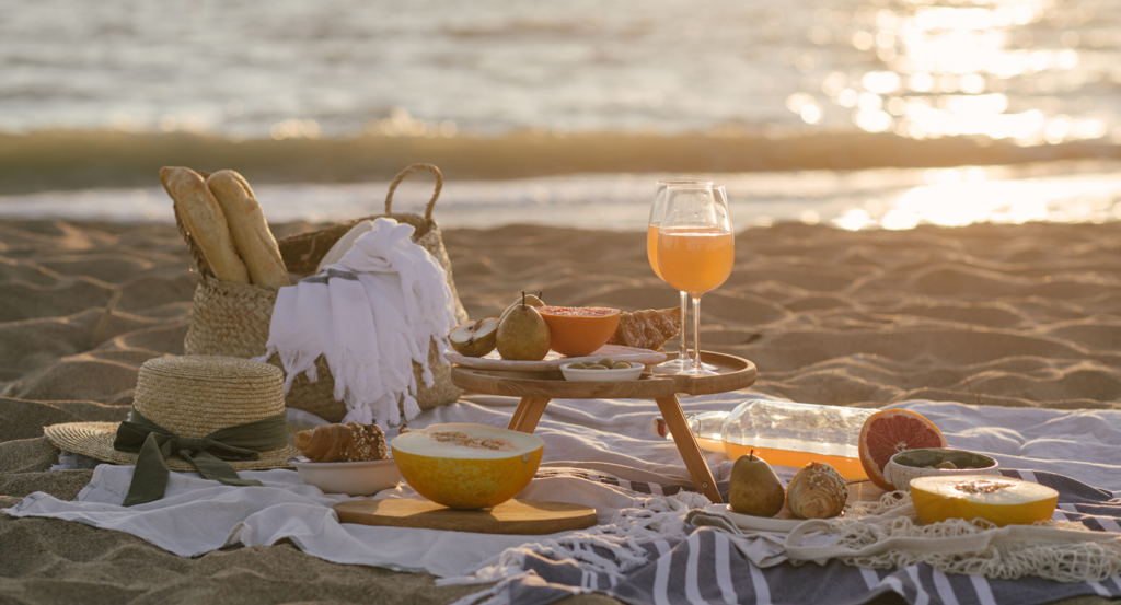 A beach picnic at sunset with the ocean in the background
