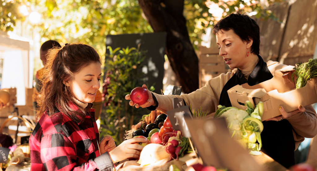 A woman buying apples at an autumn farmer's market in Malibu